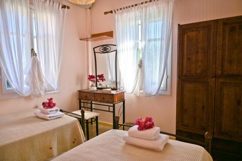 a room with two beds and a mirror and windows at Villa Ireni Waterfont in Fiskardho