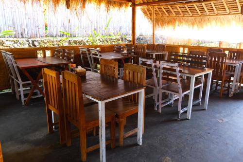 comedor con mesas y sillas de madera en Waroeng Senaru, en Senaru