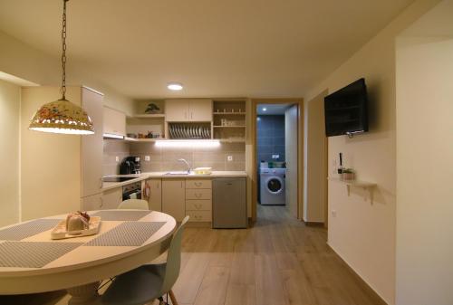eine Küche und ein Wohnzimmer mit einem Tisch und einem Esszimmer in der Unterkunft The house under the rocks of Meteora 2 in Kalambaka