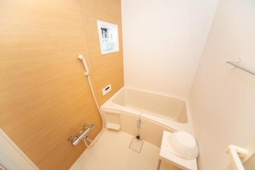 a small bathroom with a toilet and a sink at Yokkaichi Motomachi Hotel in Yokkaichi