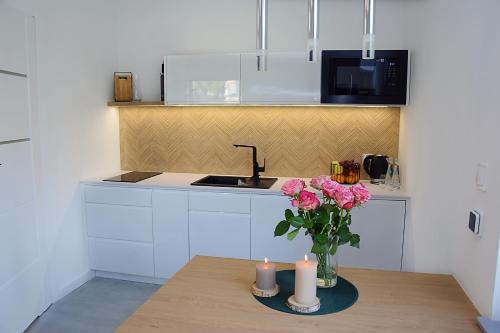 a kitchen with a table with pink flowers and candles at Gwiazda Kaszub in Chmielno