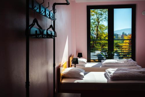 two beds in a room with a window at Tenis Park Advantage in Bielsko-Biala