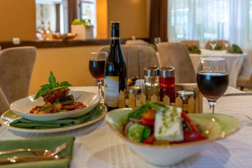 a table with a plate of food and a bottle of wine at Grami Hotel in Bansko