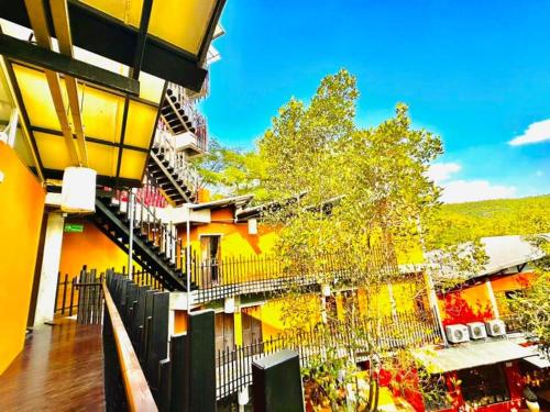 a view of a building with balconies and a tree at Hern Lhin Natural Resort in Ban Pong