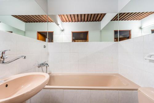 a white bathroom with a tub and a sink at Horská Chata Ještědka in Světlá pod Ještědem