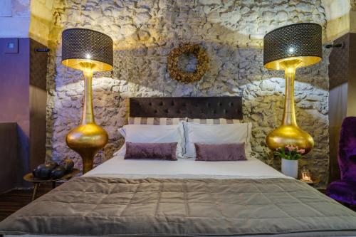 a bedroom with two lamps and a bed at Maison Boutique At Uno in San Pietro in Lama