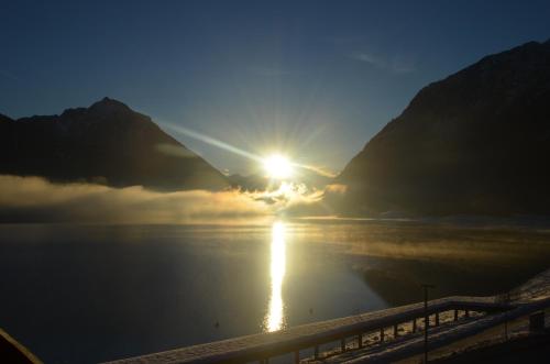 a view of the sun rising over the water at Appartements Am Achensee in Pertisau