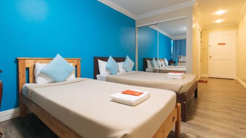 マニラにあるRedDoorz @ Manila Airport Hotelの青い壁のドミトリールーム ベッド2台