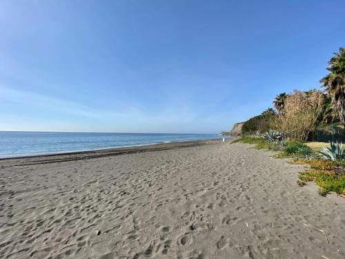 a beach with footprints in the sand and the ocean at Exclusive Beachfront Penthouse in Almayate Alto