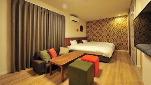 une chambre d'hôtel avec un lit et un canapé dans l'établissement RakutenSTAY x Shamaison Osaka Dekijima - 307, à Osaka