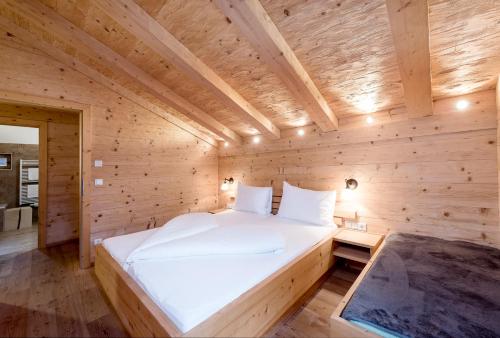 a bedroom with a bed in a wooden room at Naturresort PURADIES in Leogang