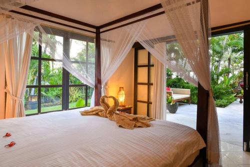 a bedroom with a large bed with a large window at Villa Branie in Temukus