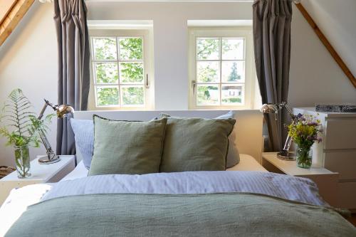 a bedroom with a bed and two windows at Schloss Mörlbach in Icking