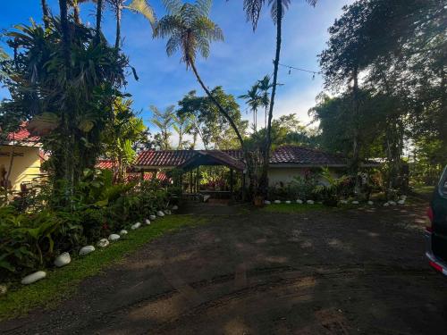 a driveway of a house with palm trees at Princesa de la Luna Ecolodge in Fortuna