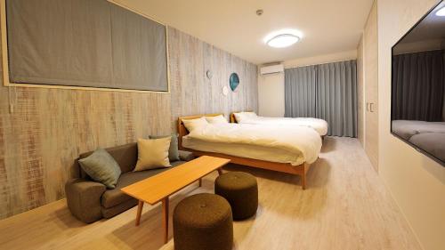Habitación de hotel con cama y sofá en RakutenSTAY x Shamaison Osaka Dekijima - 104, en Osaka