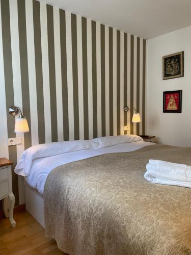 a bedroom with a bed and a striped wall at El rincón de Poniente in Gijón