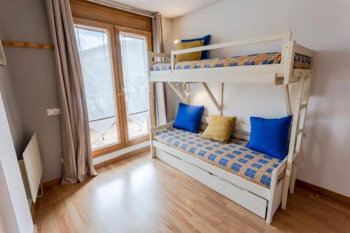 um quarto com 2 beliches e almofadas azuis em Nuria Pedrous em Pas de la Casa