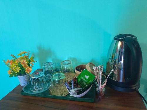a tray with glasses and other items on a table at Banorupa Kuakata hotel in Kuākāta