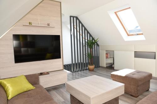 a living room with a flat screen tv and a couch at Bell Nyaraló Agárd in Gárdony