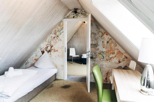 a attic room with a bed and a mirror at Fördeblick in Flensburg