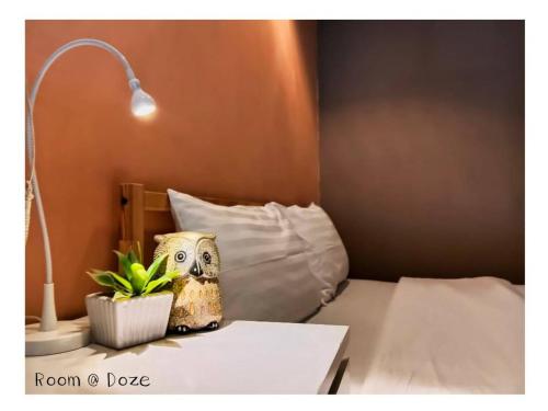 a room with a bed with a lamp and a plant at Room@Doze in Nonthaburi