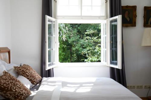 a bedroom with a bed and a window at Schloss Mörlbach in Icking