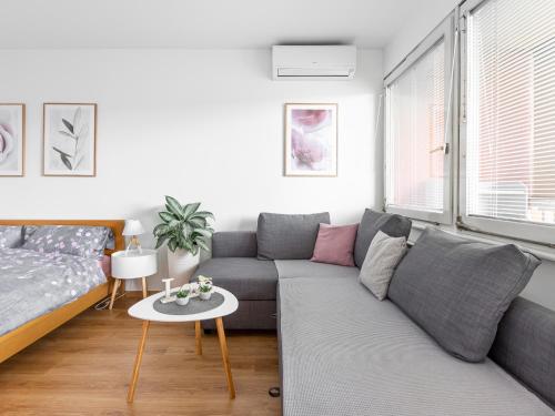 ein Wohnzimmer mit einem Sofa und einem Tisch in der Unterkunft Apartma Vrtnica 5th floor in Nova Gorica