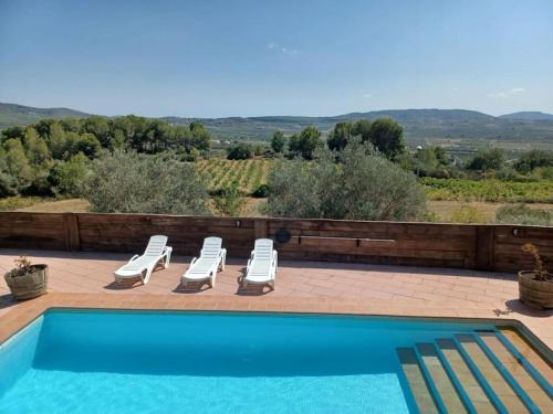 a swimming pool with two lounge chairs and a swimming pool at Breathtaking views and 2 swimming pools in Lavern