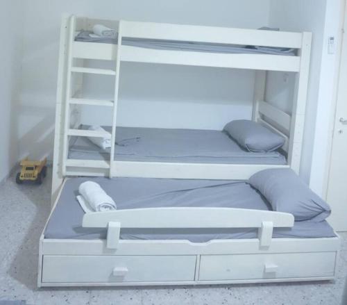 two bunk beds with pillows and a ladder at אתנחתא בכנרת in Tiberias