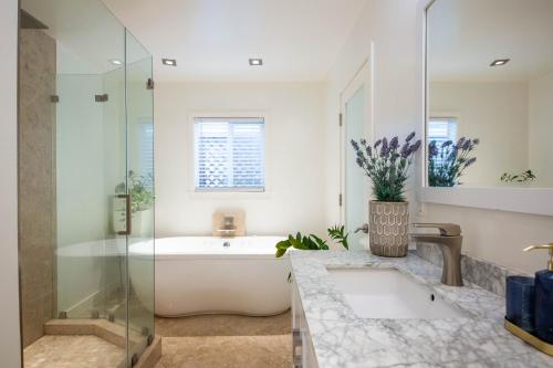 a bathroom with a tub and a sink and a shower at Overlooking Marina del Rey sailboats, is Green Ginger Playa Del Rey on the bluff, in Los Angeles