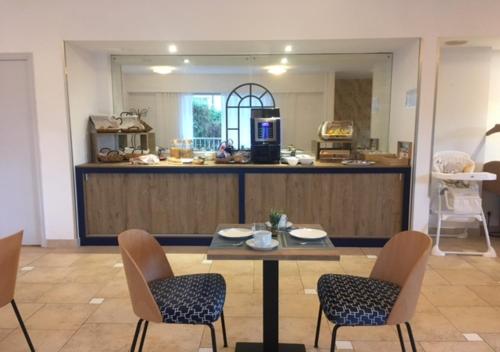 a dining room with a table and chairs and a kitchen at Résidence Carlton - Rénovée avec Piscine in Beaulieu-sur-Mer