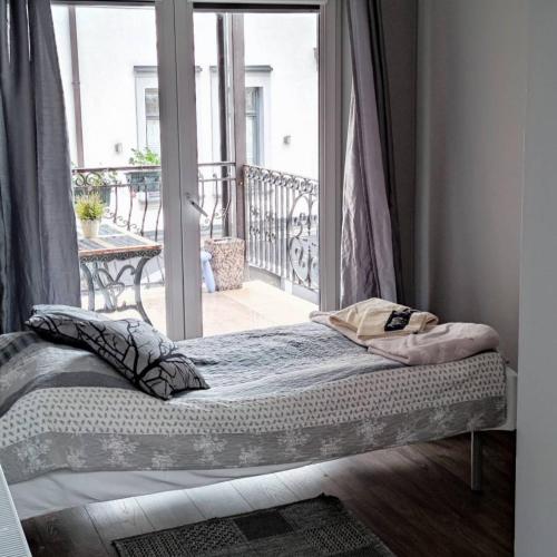 a bed in a room next to a balcony at Hotelik Kościerzyna in Kościerzyna