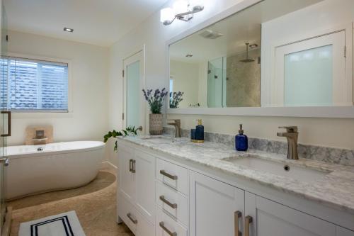 a bathroom with a sink and a bath tub and a mirror at The Green Ginger Guest House in Los Angeles