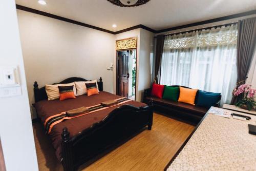 um quarto com uma cama grande e um sofá em Banchan Hostel em Phra Nakhon Si Ayutthaya