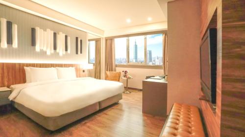 a hotel room with a bed and a large window at Hej Taipei Arena Hotel in Taipei