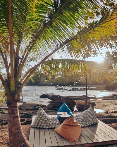 a table with pillows on a beach with a palm tree at Shantaa Resort, Kohkood in Ko Kood