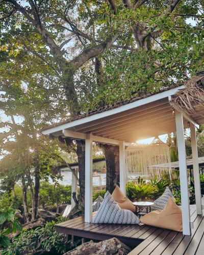 a pergola with pillows on a wooden deck at Shantaa Resort, Kohkood in Ko Kood