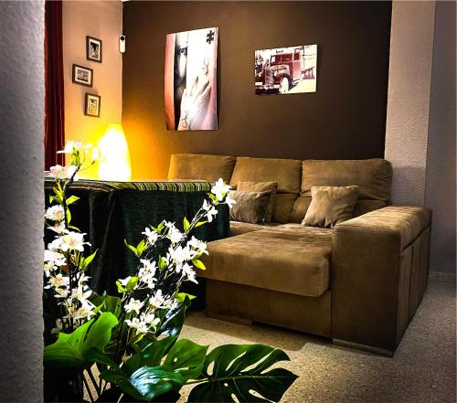 un salon avec un canapé brun et des plantes dans l'établissement Alquiler Mazagon Pre-Parque Doñana, à Mazagón