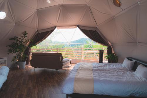 a bedroom with a bed and a couch in a tent at Blissful Garden - Vacation STAY 46374v in Shibukawa