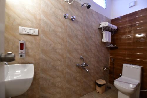 a bathroom with a toilet and a sink at Xcel Luxury Hotel Apartments-Home Living Redefined in Mysore
