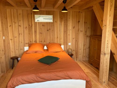 una camera da letto con un letto in una cabina di legno di :Le tchanqué du bassin d'arcachon a Lège-Cap-Ferret