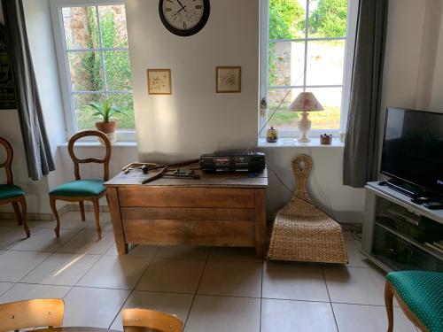 - un salon avec une table en bois et une télévision dans l'établissement Busset Liages situé dans le Bourbonnais 1 chambres lit double et un clic clac, à Busset