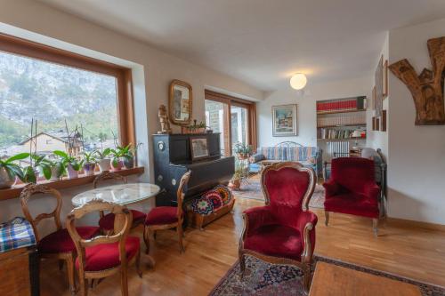 a living room with red chairs and a table at Hotel Berthod in Courmayeur