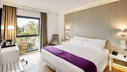 um quarto de hotel com uma cama grande e uma janela em Sercotel Amistad Murcia em Múrcia