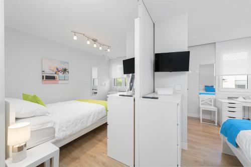 een witte slaapkamer met een bed en een bureau bij Solaga - Carmen Beach in Málaga