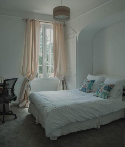 une chambre avec un grand lit avec une fenêtre dans l'établissement Chateau la Tilleraie, à Bergerac