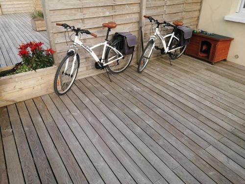 2 bicicletas están estacionadas en una terraza de madera en gite repos et tranquillité G en Cayeux-sur-Mer