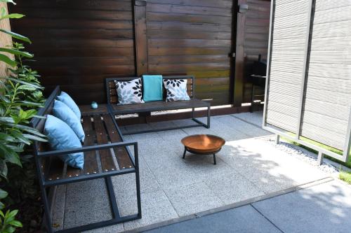 a patio with two benches and a table at Bell Nyaraló Agárd in Gárdony