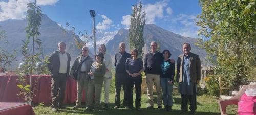 a group of people posing for a picture with mountains in the background at Karakorum View Hotel Karimabad Hunza in Hunza