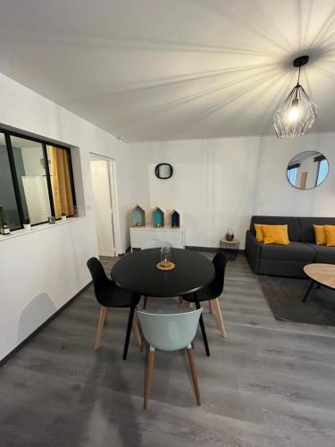 un salon avec une table et un canapé dans l'établissement Appartement cosy hyper centre colmar, à Colmar